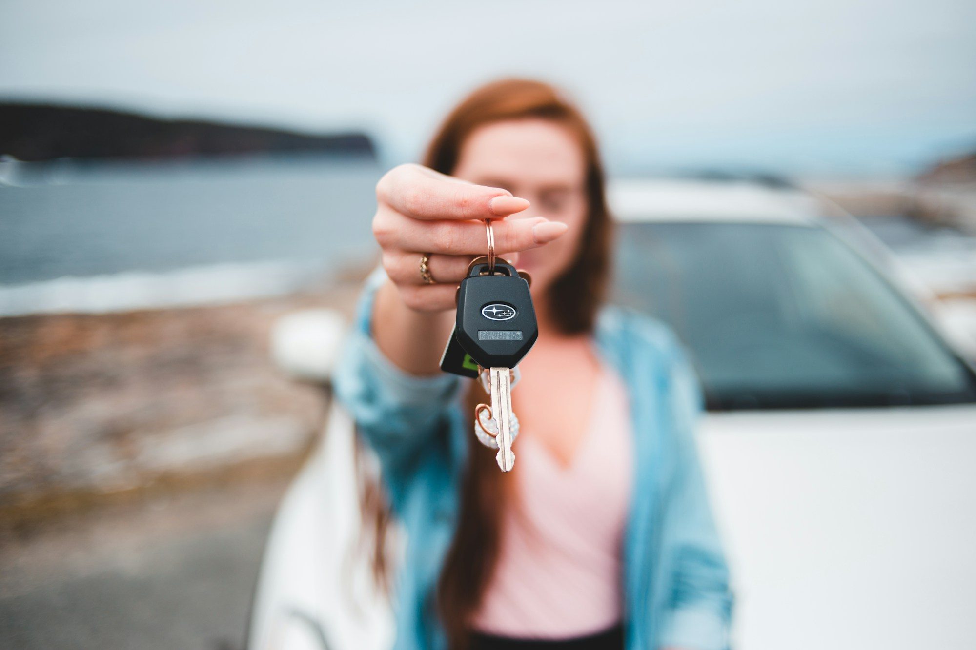 A woman holding up a car key
